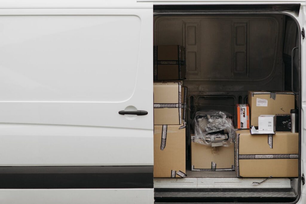 pexels photo 6407553 Open delivery van filled with boxes, ready for logistics and transport services.